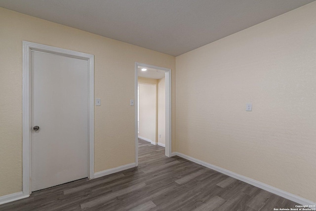 empty room featuring wood finished floors and baseboards