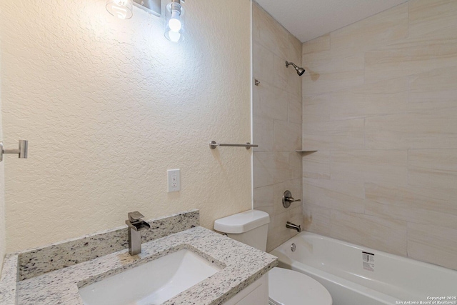 bathroom featuring toilet, bathing tub / shower combination, vanity, and a textured wall