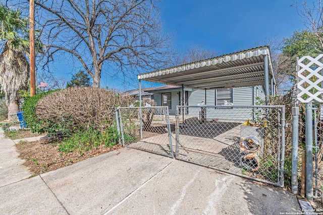 view of front of home featuring a gate, fence, concrete driveway, and a detached carport