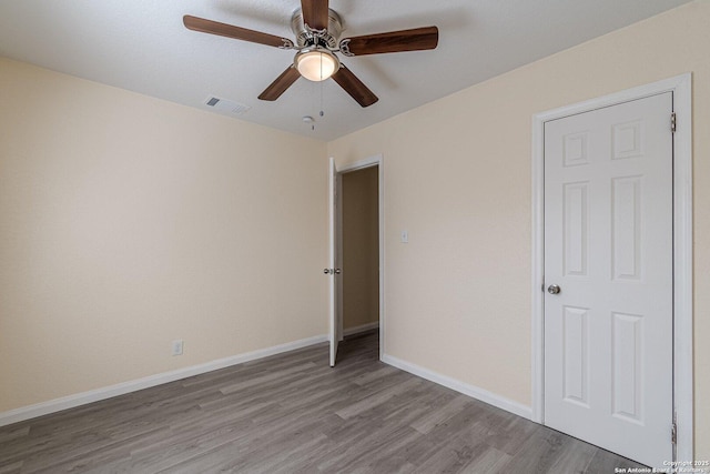 unfurnished bedroom with visible vents, ceiling fan, baseboards, and wood finished floors