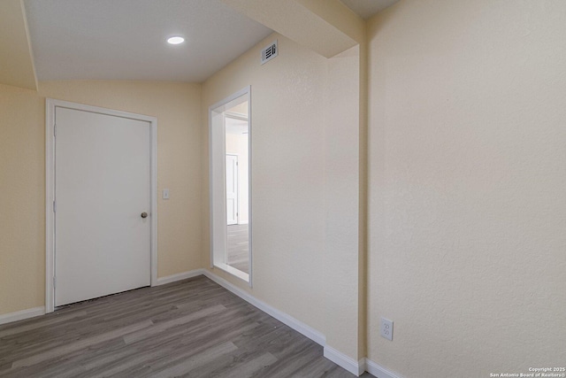 foyer with baseboards, visible vents, and wood finished floors