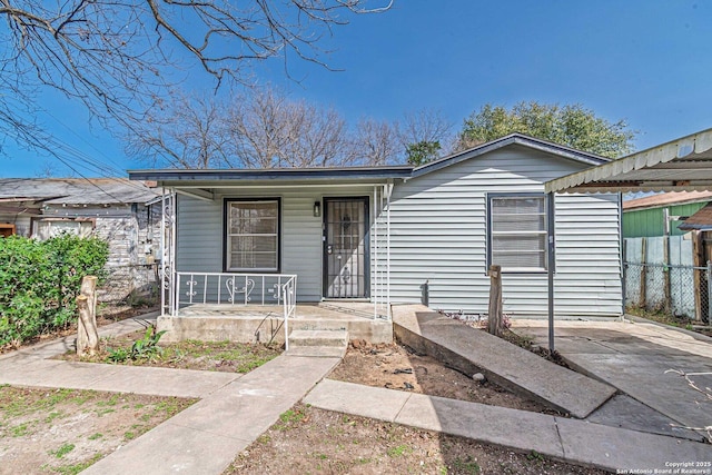 bungalow-style house with covered porch and fence