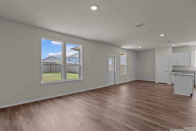 unfurnished living room with dark wood-style floors, recessed lighting, visible vents, and baseboards