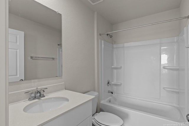 bathroom featuring a textured wall, shower / tub combination, vanity, and toilet