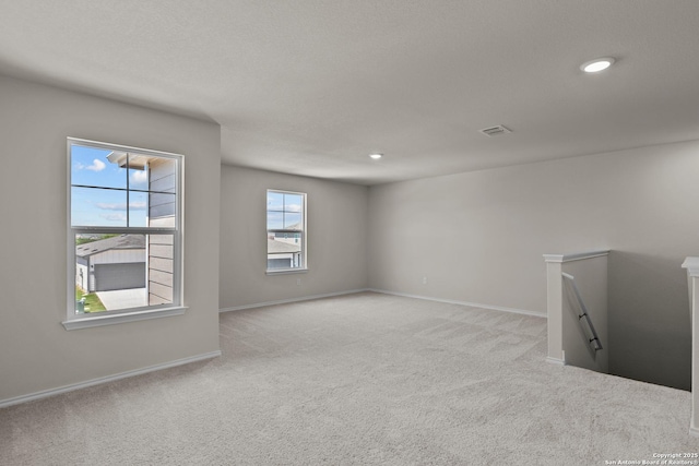 carpeted empty room with a textured ceiling, recessed lighting, visible vents, and baseboards