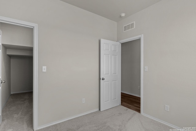 unfurnished bedroom featuring carpet, visible vents, and baseboards