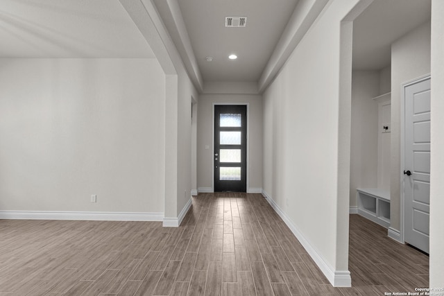 entrance foyer with baseboards, visible vents, arched walkways, wood finished floors, and recessed lighting