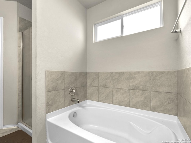 bathroom featuring a garden tub and a stall shower