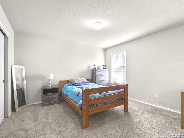 carpeted bedroom featuring baseboards and a textured ceiling