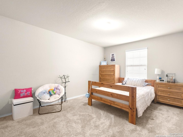 bedroom featuring carpet floors, baseboards, and a textured ceiling