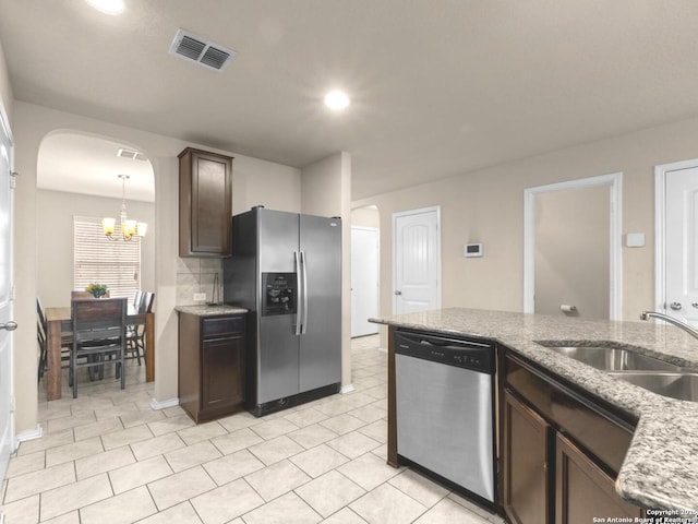 kitchen with arched walkways, visible vents, an inviting chandelier, appliances with stainless steel finishes, and a sink