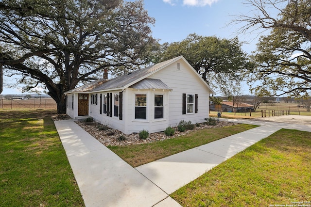 view of home's exterior with a lawn and fence