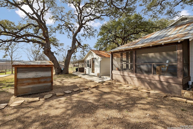 view of yard with an outbuilding and a sunroom