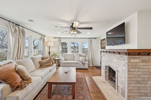 living room featuring recessed lighting, a fireplace, wood finished floors, visible vents, and a ceiling fan