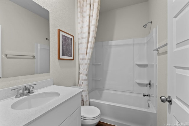 bathroom featuring toilet, a textured wall, shower / tub combo with curtain, and vanity