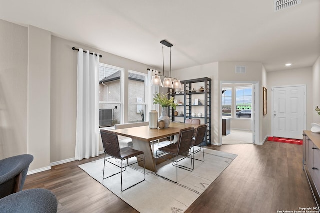 dining area featuring wood finished floors, visible vents, and baseboards