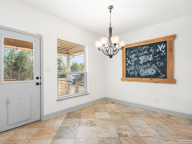 unfurnished dining area with an inviting chandelier and baseboards