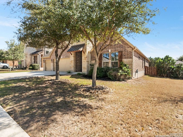 view of front of home featuring fence, an attached garage, concrete driveway, stone siding, and brick siding