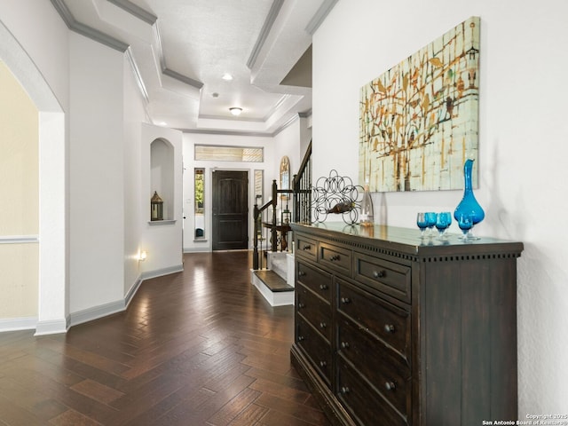 entrance foyer with a raised ceiling, stairway, arched walkways, baseboards, and parquet flooring