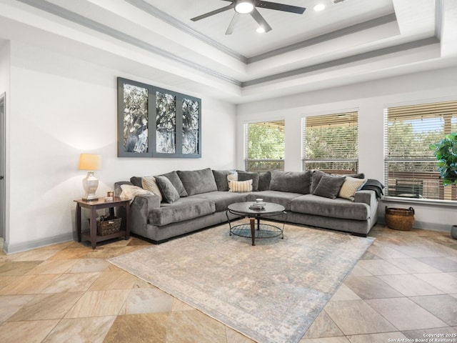 living room featuring a wealth of natural light, baseboards, crown molding, and a tray ceiling