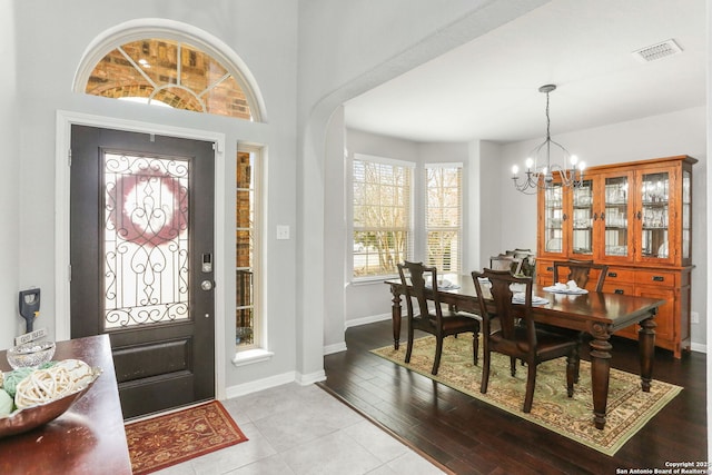 entrance foyer with baseboards, visible vents, a chandelier, and wood finished floors