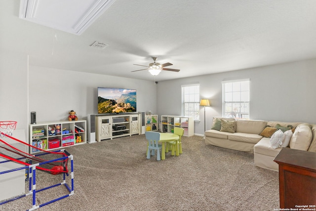 rec room with visible vents, ceiling fan, carpet, and attic access