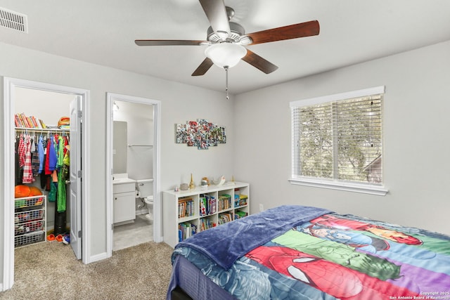 bedroom with ensuite bathroom, visible vents, a spacious closet, a closet, and carpet