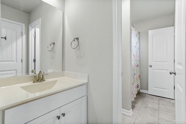 bathroom featuring vanity, baseboards, and tile patterned floors