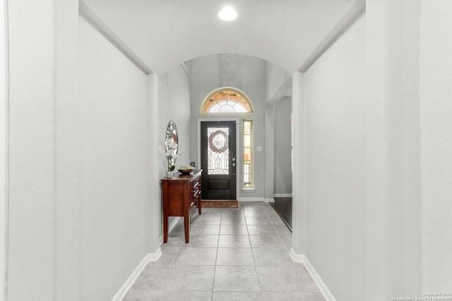 entrance foyer featuring lofted ceiling, baseboards, and arched walkways