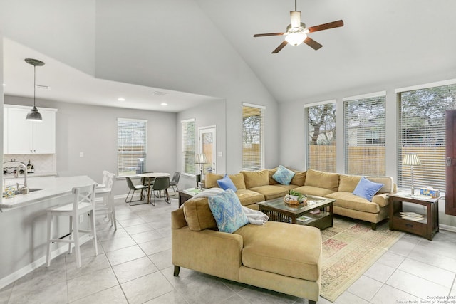 living room featuring light tile patterned floors, baseboards, and a ceiling fan