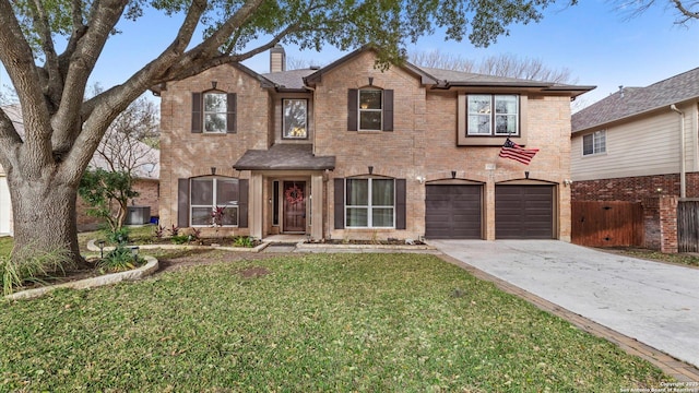 traditional home featuring concrete driveway, an attached garage, fence, a front lawn, and brick siding