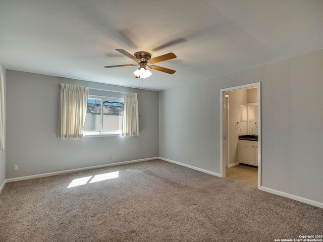 unfurnished room featuring a ceiling fan, light colored carpet, and baseboards