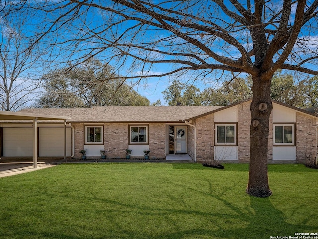 view of front facade with a front lawn, an attached garage, and brick siding