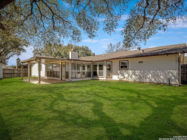 back of property with a patio, a fenced backyard, a sunroom, a lawn, and a chimney