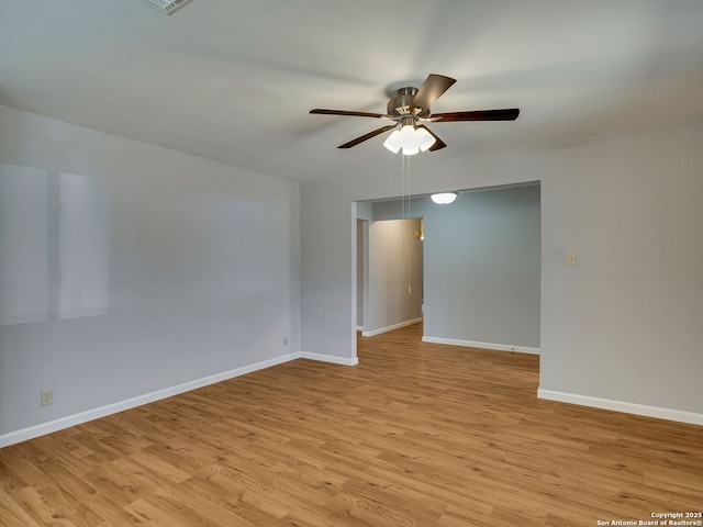 spare room with light wood-type flooring, ceiling fan, and baseboards