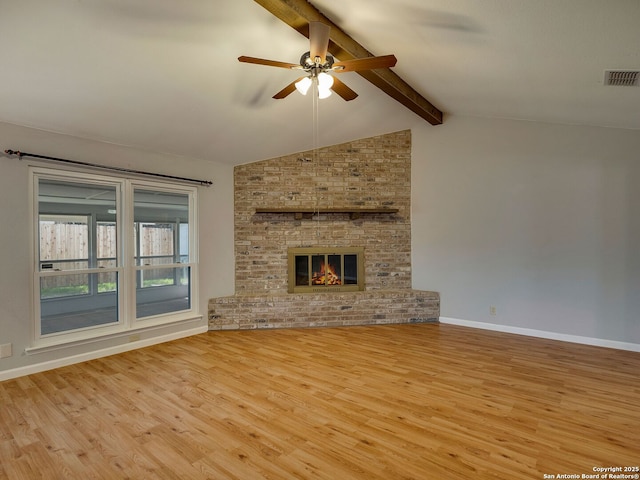 unfurnished living room with baseboards, visible vents, wood finished floors, vaulted ceiling with beams, and a fireplace