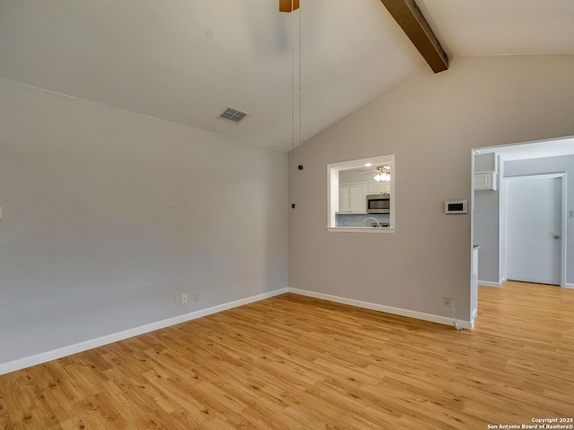 empty room with beam ceiling, visible vents, ceiling fan, light wood-type flooring, and baseboards