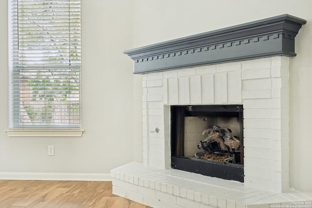 interior details featuring a fireplace, baseboards, and wood finished floors