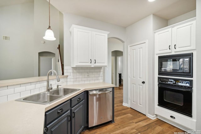 kitchen with visible vents, backsplash, white cabinets, a sink, and black appliances