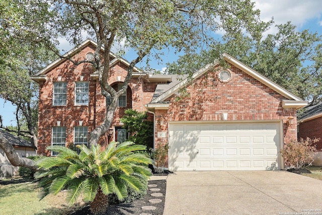 traditional-style home featuring an attached garage, concrete driveway, and brick siding