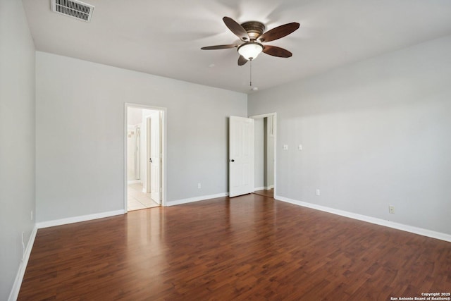 unfurnished room featuring a ceiling fan, baseboards, visible vents, and wood finished floors