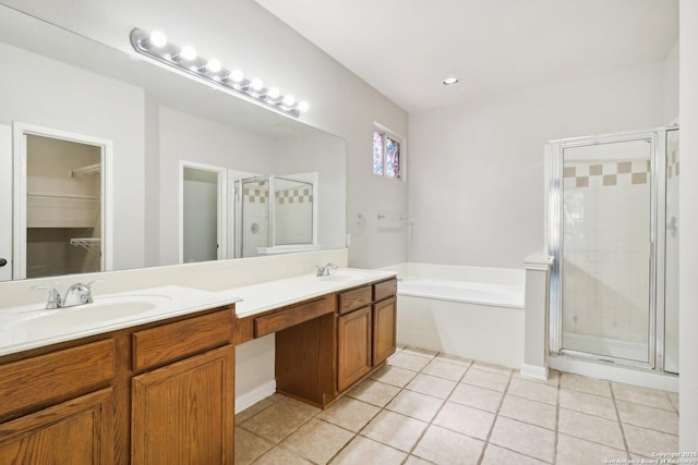 bathroom featuring a garden tub, a stall shower, tile patterned flooring, and a sink