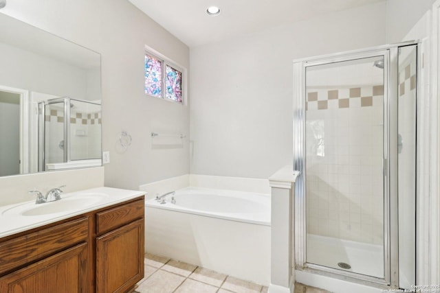 bathroom featuring a stall shower, tile patterned floors, a garden tub, and vanity