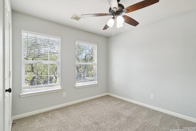 empty room with carpet, visible vents, baseboards, and ceiling fan