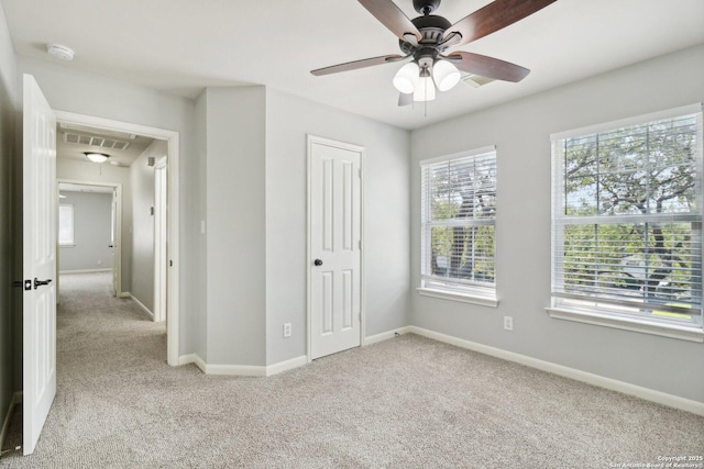 unfurnished bedroom featuring attic access, light colored carpet, visible vents, and baseboards