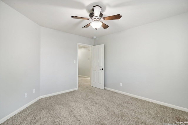 empty room featuring light carpet, baseboards, and a ceiling fan