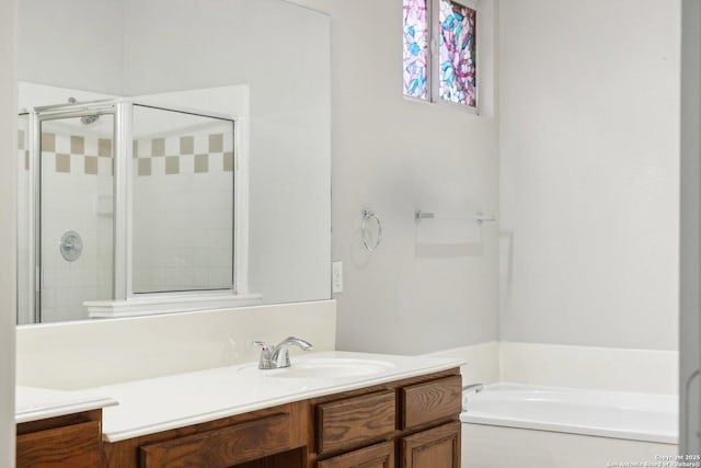 bathroom with a shower stall, a bath, and vanity