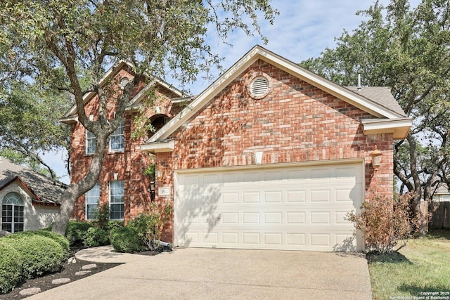 traditional home with a garage, concrete driveway, and brick siding