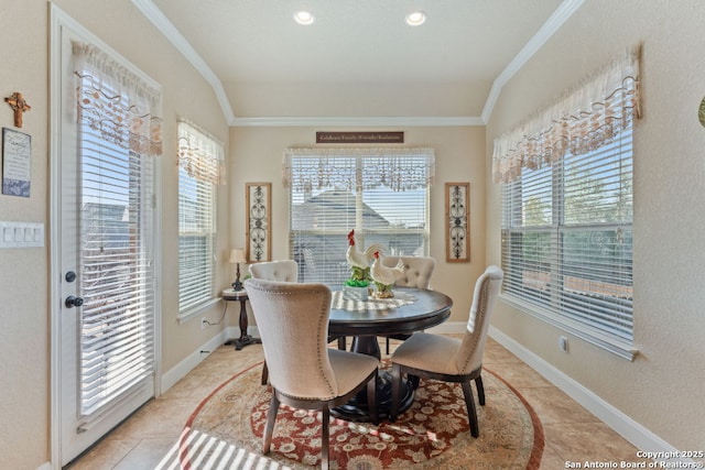 dining room with baseboards, a healthy amount of sunlight, light tile patterned flooring, and crown molding