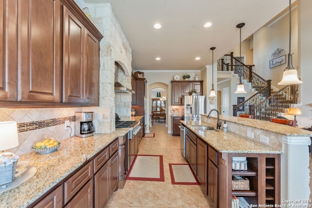 kitchen with arched walkways, decorative backsplash, stainless steel fridge with ice dispenser, light stone countertops, and a sink